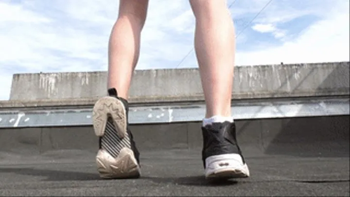 Red-haired chick in black Reebok sneakers walks on the roof, fc188x