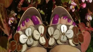 Feet in purple nail polish with high heels wooden mules