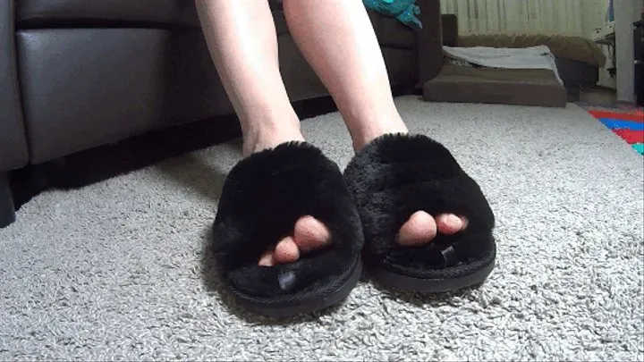 Toe wiggling in plush black slippers