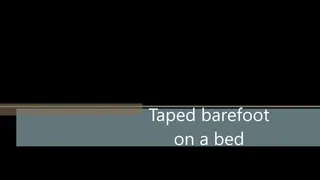 Taped barefoot on the bed