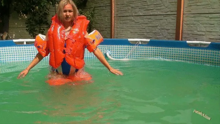 Christina deflates arm wings and life vest in an outdoor pool