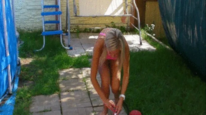 Christina pumps up a pink gymnastic ball with foot pump