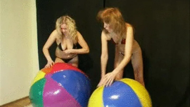 2 girls riding and deflating beachballs