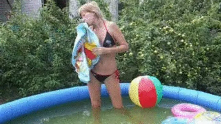 Alina blows up and plays with a swimring in the pool