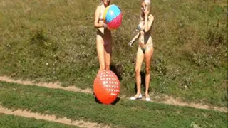 Alina and Christina deflating beachballs outdoors