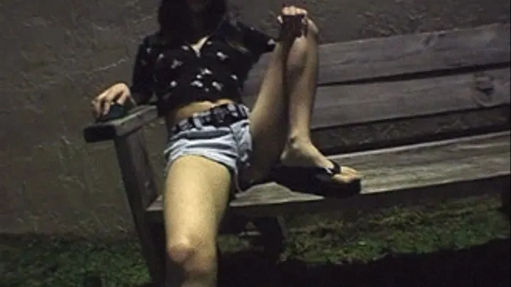 Dark hair babe smoking cigarette outside at night on bench Mobile