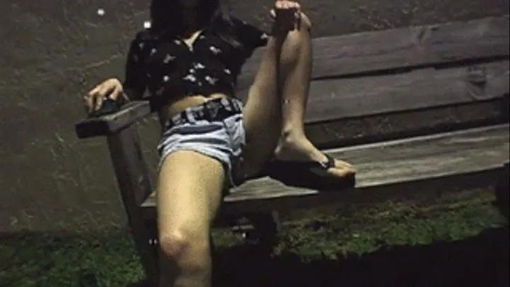 Dark hair babe smoking cigarette outside at night on bench Format