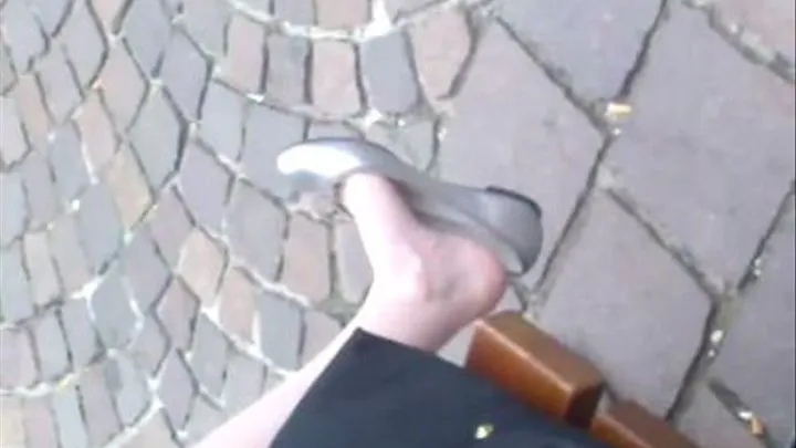 Barefeet in flats dangling on a bench