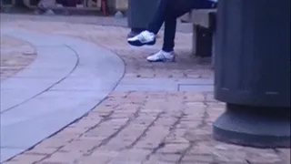 White Adidas sneakers on a bank