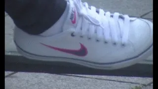 White Nike sneakers at the bus stop