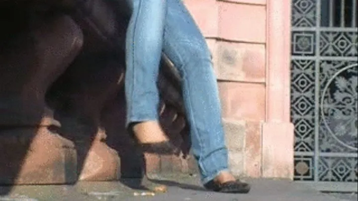 Jeans legs with Pumps whipping on a wall