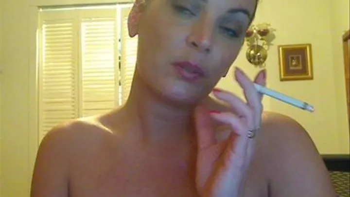 Desireye's doing make up and smoking a cigerette topless