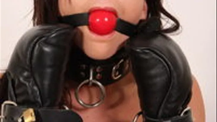 Bella in locking leather mitts, red ballgag, and locking straps