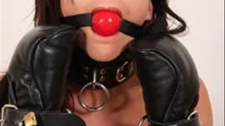 Bella in locking leather mitts, red ballgag, and locking straps