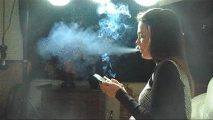 KRISTEN BLOWS SMOKE AT HER CELL-PHONE