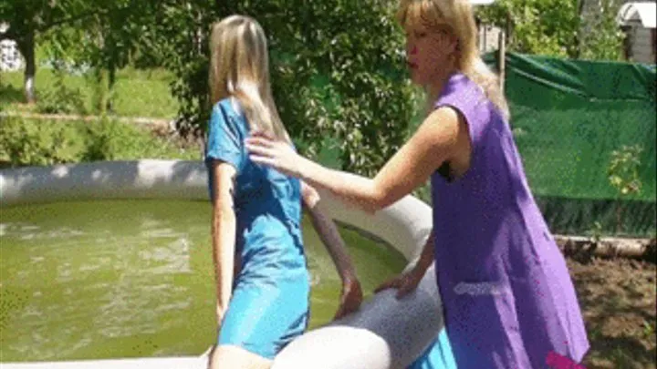 2 girls in Smocks playing in a outdoor pool