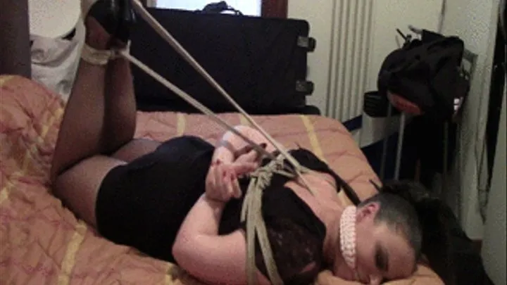 Gina hogtied on a bed