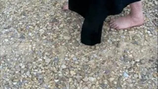 Barefoot Cecilia walking on stones