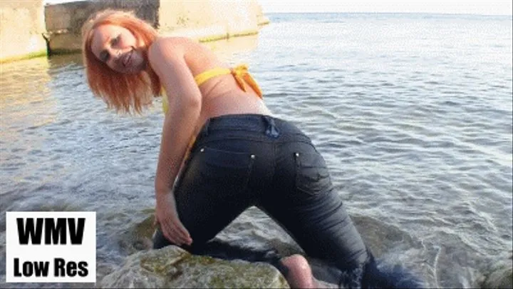 Getting into the sea with her jeans