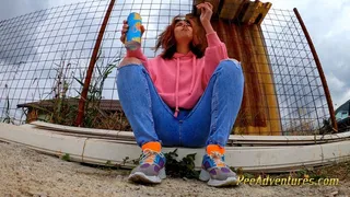 Pissing trough her jeans outdoor