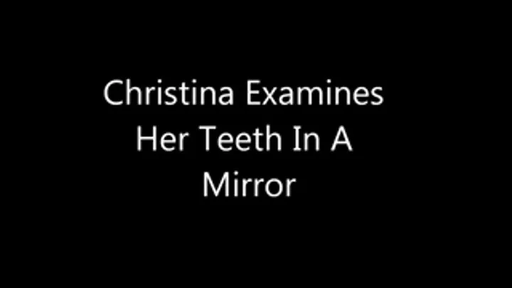 Christina examines her teeth in a mirror