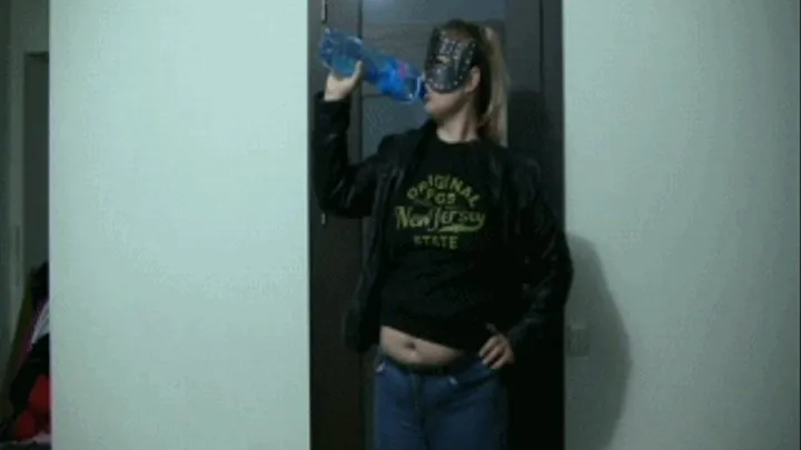 Playing with a belly in jeans and a small sweater in a mask.