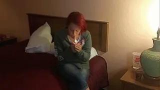 Kori smokes in her motel room