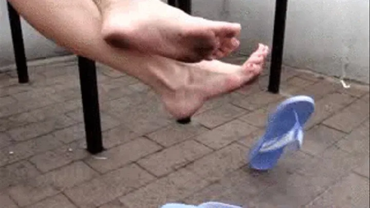 Dirty feet dangling with flip flops