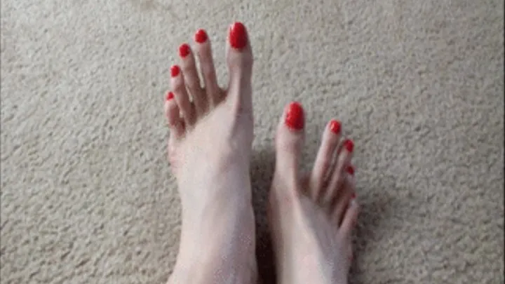 Freshly painted long toes are shiny red POV