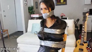 Elsa del Rey tightly taped to a chair, zip ties over the tape and cruelly wraparound tape gagged