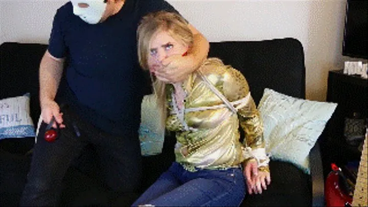 Dresden wearing a shiny golden blouse and jeans is a cowgirl held for ransom, cleave gagged and then ballgagged