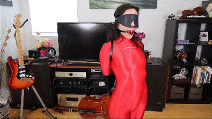 Khrystal in full shiny red bodysuit completely bound with armbinder, handcuffs, leather blindfold, then with tight rope and tape gagged