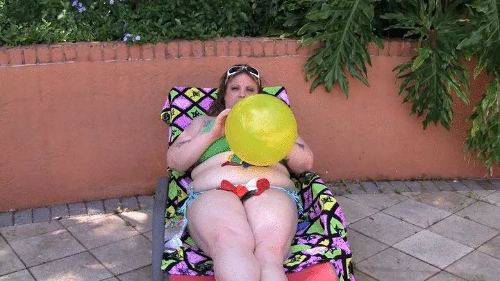 Jenna Devyne is blowing up balloons out by the pool in a bikini.