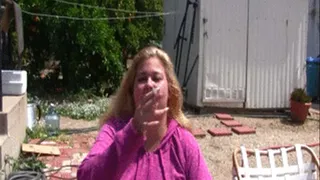 BBW Lola LoveBug is sitting outside smoking wearing purple jacket and is already smoking and smokes another cigarette.