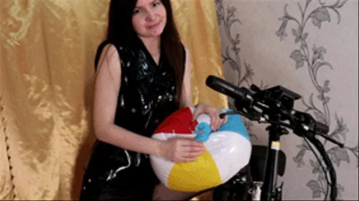 Biker girl deflates a beach ball