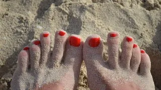 Red toes on sand
