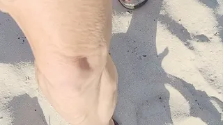 Walking in sand in black thong flip flops