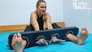 Tickling her sexy feet locked in stocks
