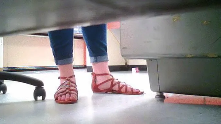 woman with big feet wearing sandals under desk