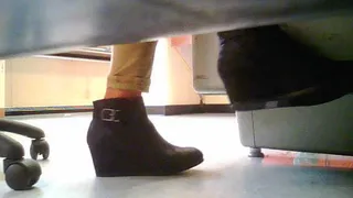 teacher wearing black ankle boots under desk