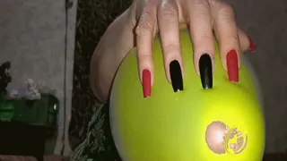 Red and black nails against balloons