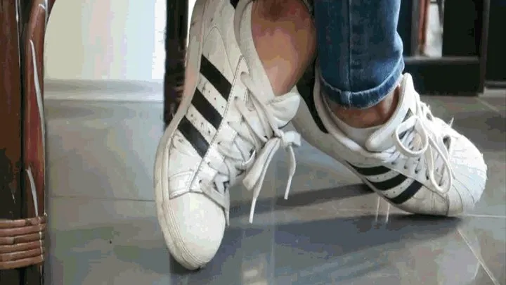 In sneakers, looking under the table