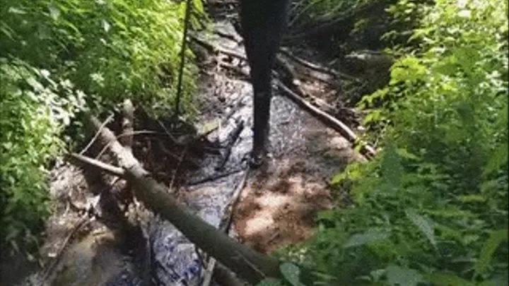 Black rubber boots in a stream