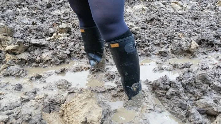 Muddy ground and black rubber boots