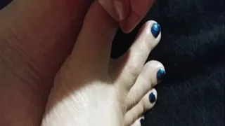 Close up toes of removing dark toenail Polish and repainting