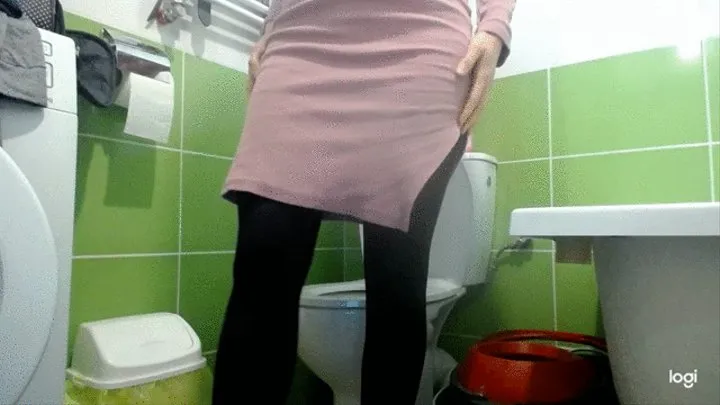 I pee standing on the toilet bowl in pink dress