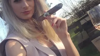 Sexy blonde smokes a large cigar in public