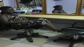 Baaba the Hairstylist Crosses Wrinkled Ebony Soles on Chair in Salon