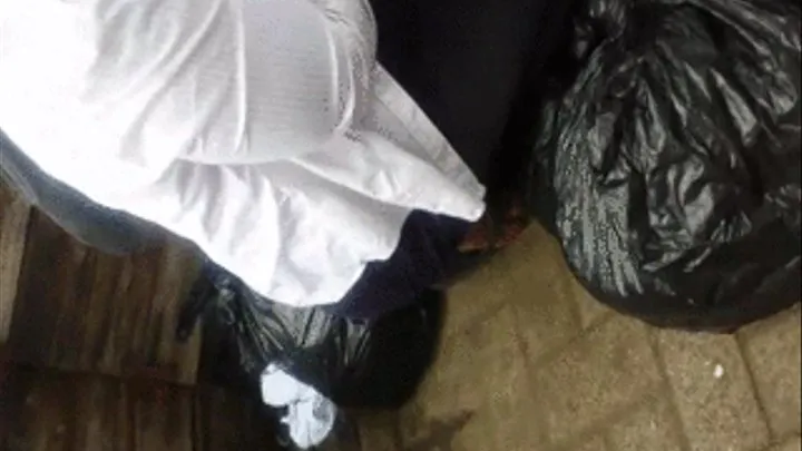 Tema Station Clothing Vendor Bends Down in Flip Flops (Joined Clip)