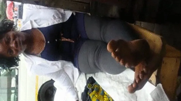 Tema Station Clothing Vendor Crosses Dirty Ebony Soles at Ankles